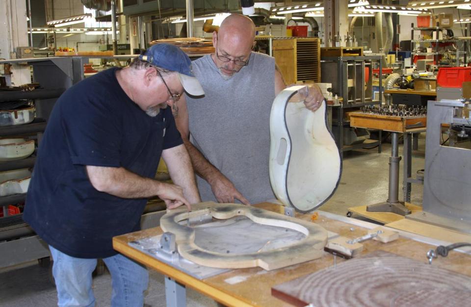 Plant manager Darren Wallace (left) and Joe Martocchio examined a guitar being built at Ovation’s factory in Connecticut.